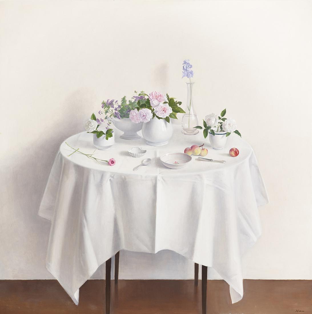 Table with flowers and white table cloth on white background